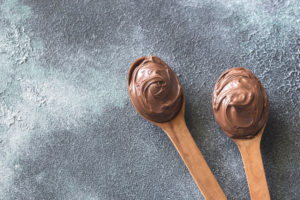 Two wooden spoons of chocolate cream